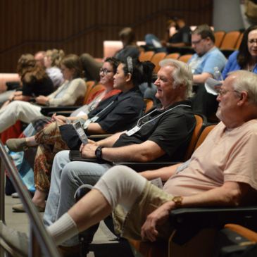 Audience attentively seated in a conference or seminar setting.