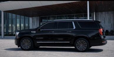 Black luxury SUV parked outside a modern building.