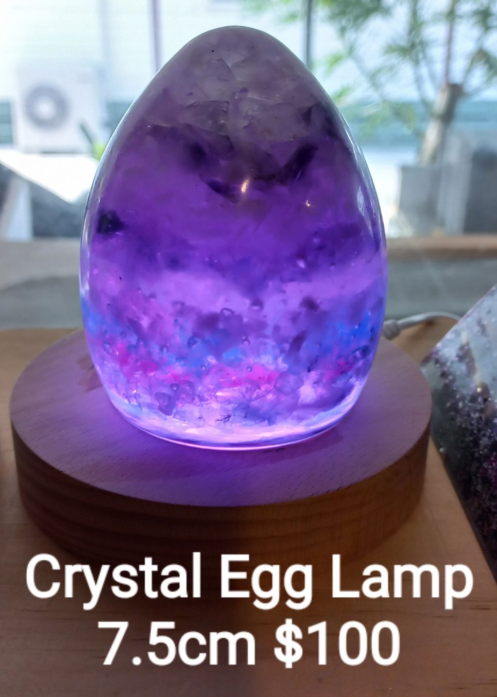 Purple crystal egg lamp glowing on wooden base.