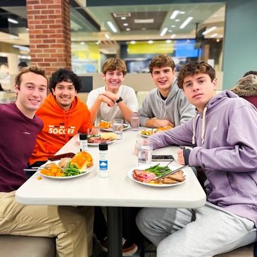 Group of college students dining at a table.