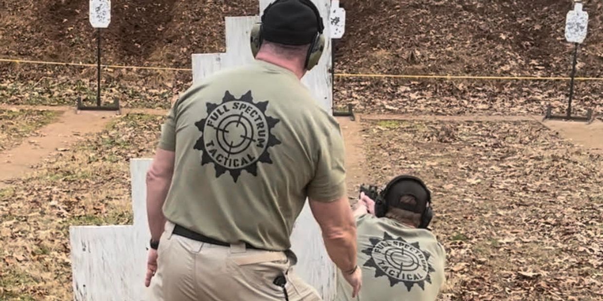 Two people practicing defensive pistol techniques