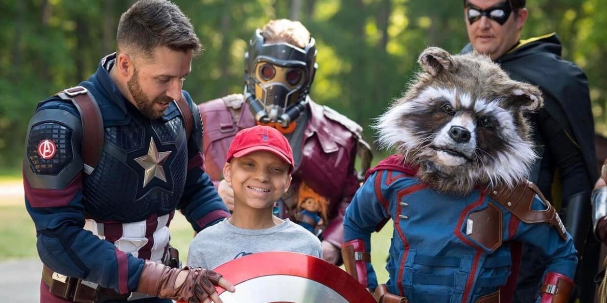 Child with people dressed as Marvel superheroes.