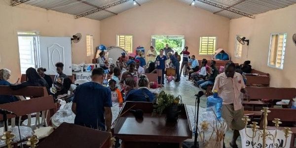 Community members gather in a church hall for a meeting or event.