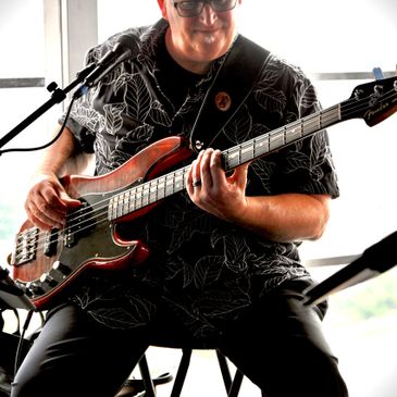 Musician playing an electric bass guitar during a live performance.