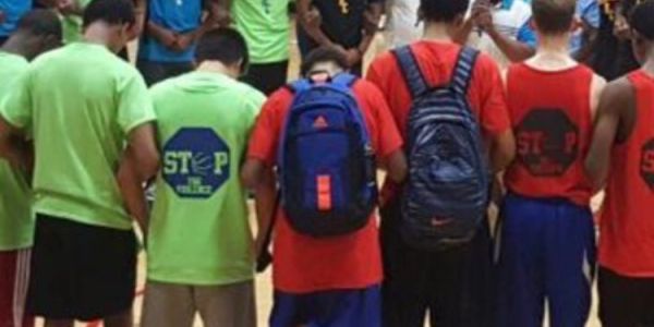 A group of young people standing and holding hands in a circle.