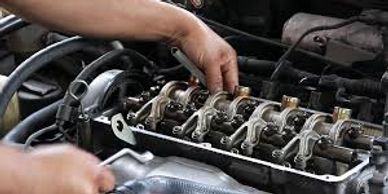 Mechanic with wrenches in both hands working on a car engine
