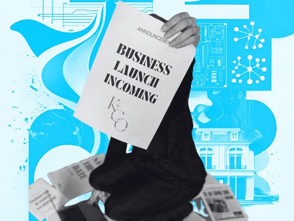 Person holding a paper announcing a business launch amidst newspapers and a laptop.