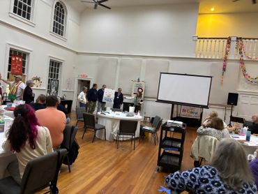 People attending a community meeting in a hall.