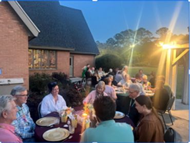 Outdoor evening gathering with people dining.