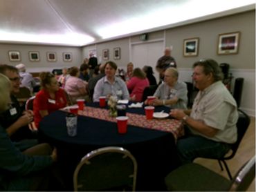 People gathered around a table at a social event.