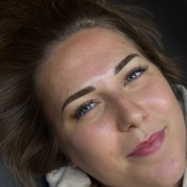 Close-up of a woman with well-groomed eyebrows and light makeup.