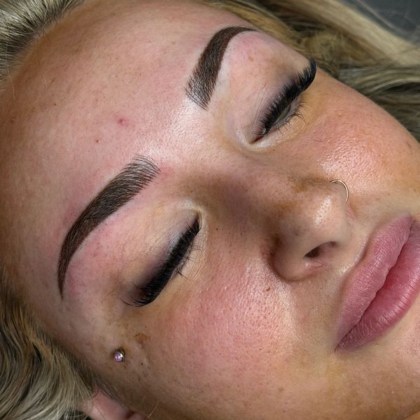 Close-up of a woman's face with closed eyes and well-defined eyebrows.