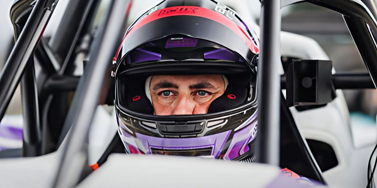Race car driver in helmet focused inside the vehicle.