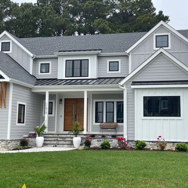 Modern gray house with a spacious lawn and front porch.