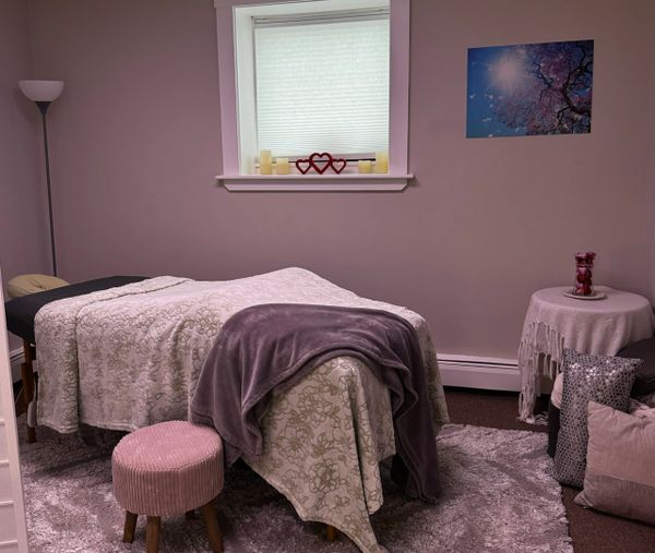 Treatment room beautifully decorated in soft colors, massage table