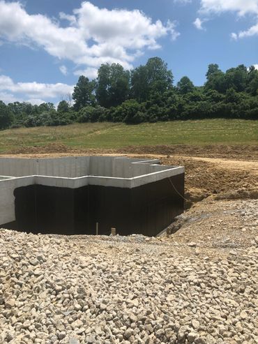 Foundation of a building under construction in a rural landscape.