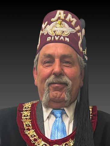 Man wearing a ceremonial fez hat and robe with ornate gold decorations.