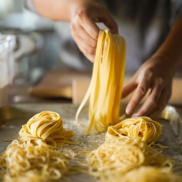 Hands preparing fresh pasta nests.