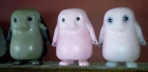 Three cute, rounded figurines with smiling faces and big eyes.