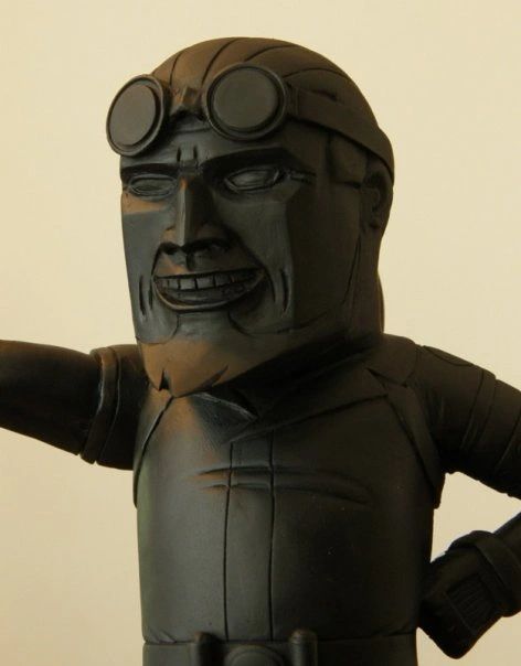 A black sculpture of a man wearing goggles and a helmet, smiling.