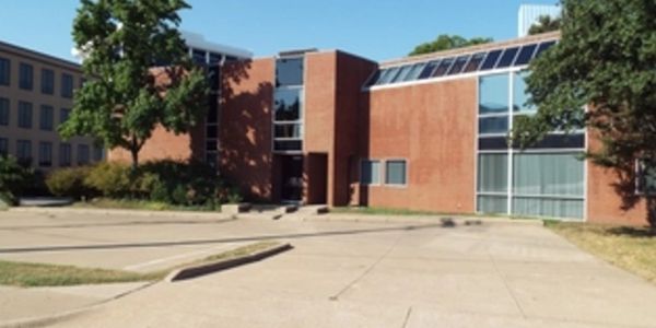 Modern brick building with large windows and solar panels on the roof.
