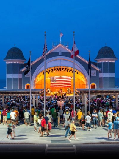 Crowd enjoying a concert at an outdoor pavilion.