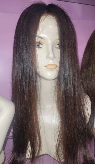 Mannequin head with long straight brown hair against a purple background.