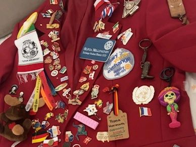 A collection of colorful pins and keychains on a red fabric.