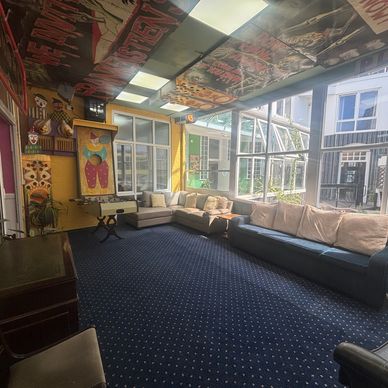 Bright sunroom with large windows and sofas.