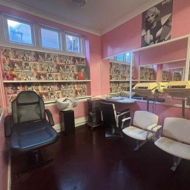 Interior of a vintage-style salon with pink walls and retro decor.