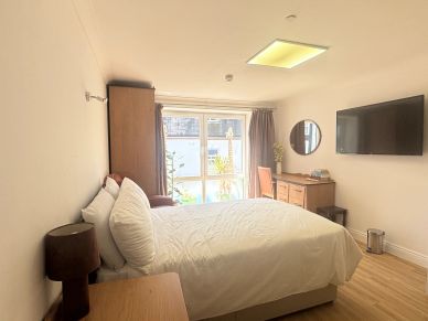 Bright, cozy bedroom with a large bed and natural light.