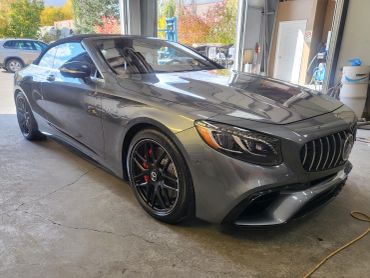 Gray luxury convertible car parked indoors.