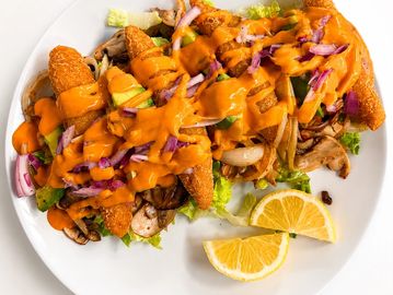 Tacos de poisson croustillants garnis de légumes frais, d’oignons marinés et d’une sauce crémeuse re