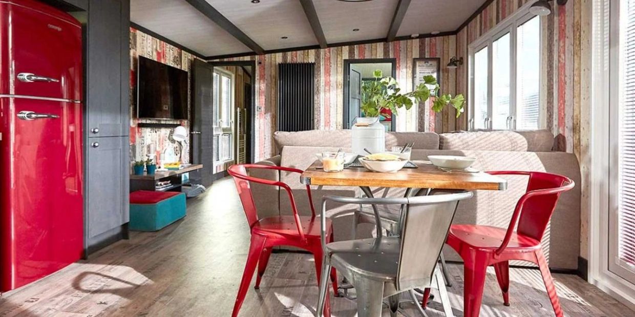 Cozy dining area with colorful chairs and a vintage fridge.