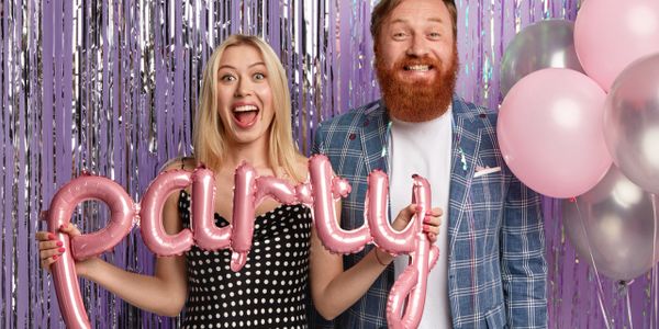 Couple celebrating with pink party balloons