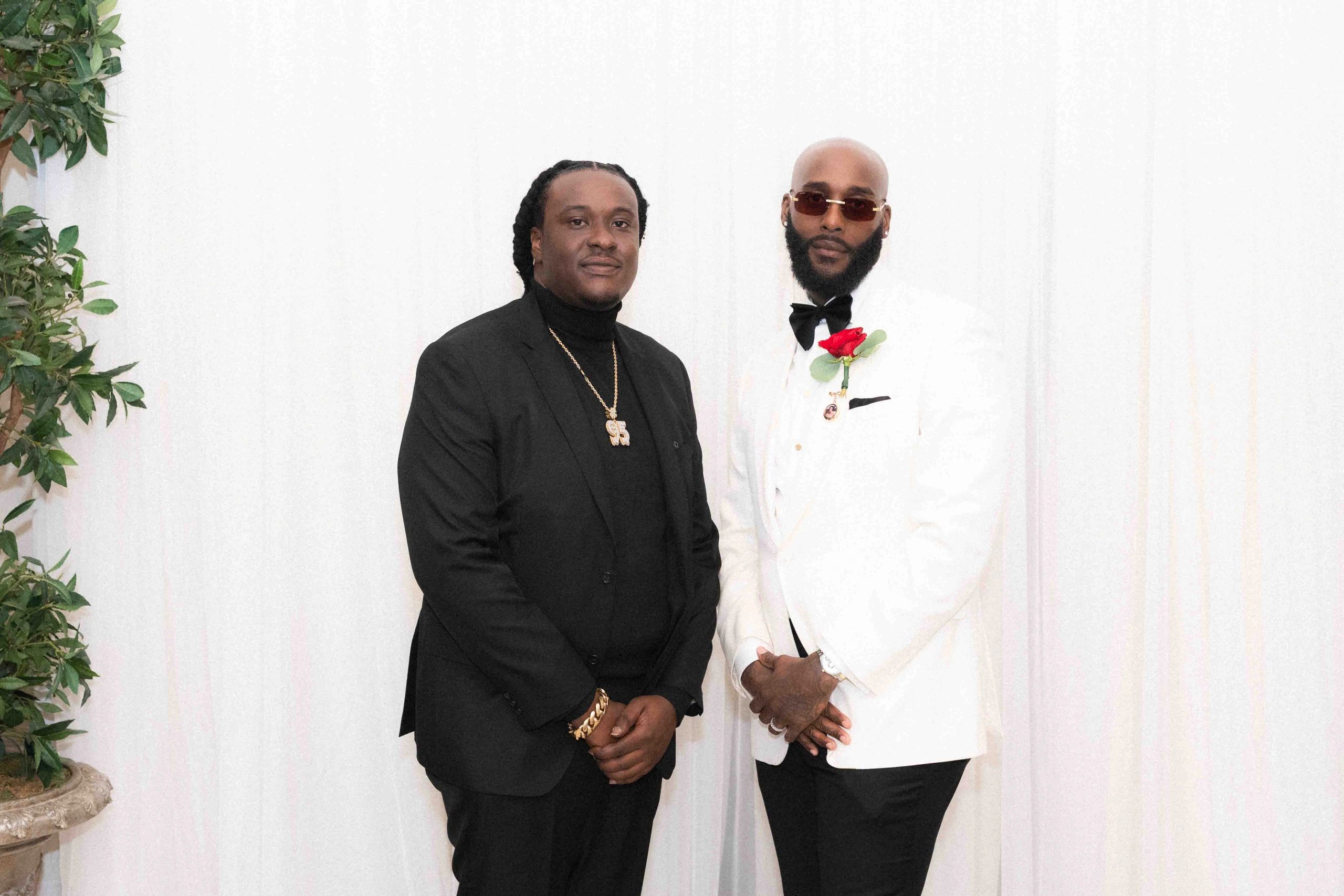 Two men dressed formally against a white backdrop.