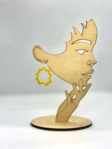 Yellow floral earrings on wooden stand