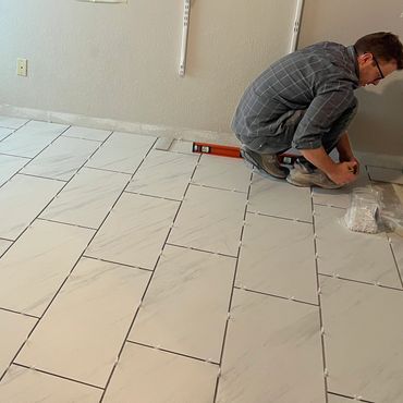 Replaced carpet, tile, and glued down linoleum with porcelain tiles throughout this rental property.