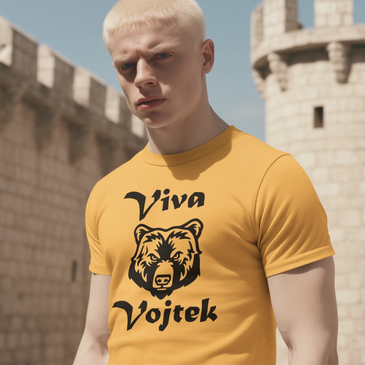 White European man standing in front of a castle wearing T Shirt which reads Viva Vojtek.