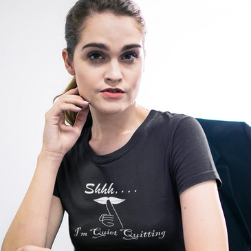 Woman in office wearing black T-Shirt with text Shhh... I'm Quiet Quitting.