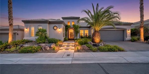 Elegant house with palm trees at sunset.
