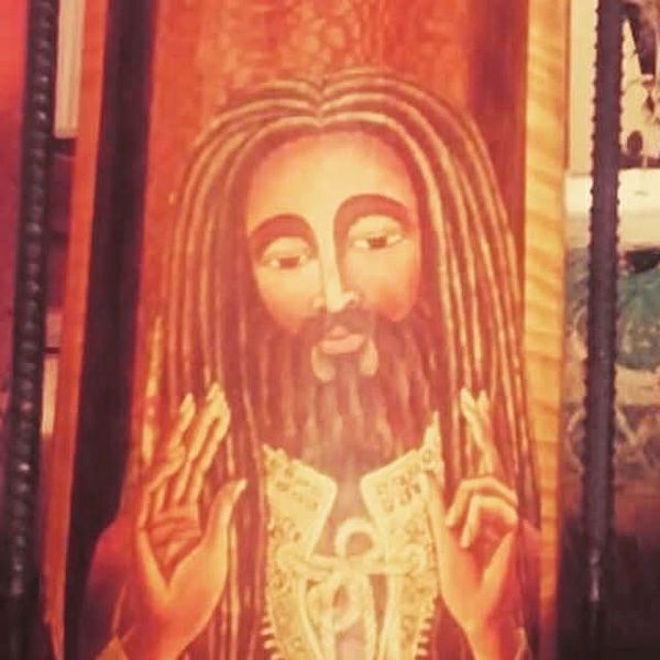 Painting of a bearded figure with dreadlocks and raised hands.