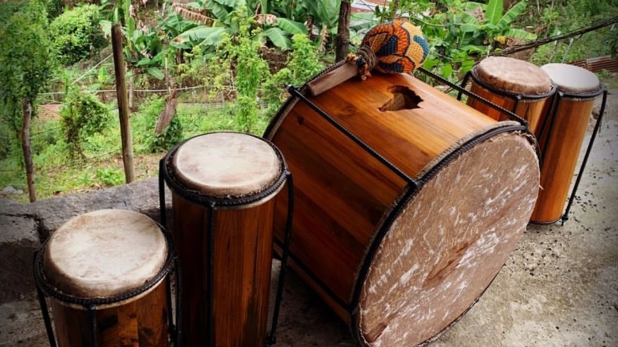 Traditional wooden drums with natural skins arranged outdoors.