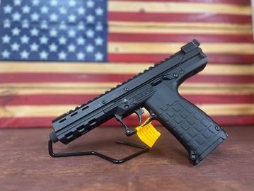 Black handgun on stand with American flag background.