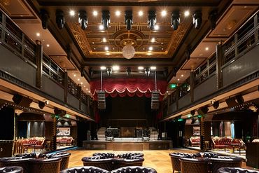 Elegant theater auditorium with stage and balcony seating.