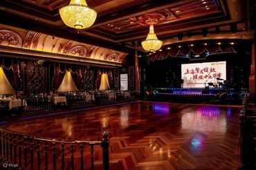 Luxurious ballroom with wooden floor and grand chandeliers.