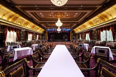 Elegant dining room with a long table and ornate decor.