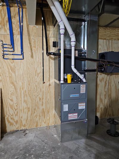 An installed Daikin home  furnace positioned neatly in residential basement with sleek clean ducts.