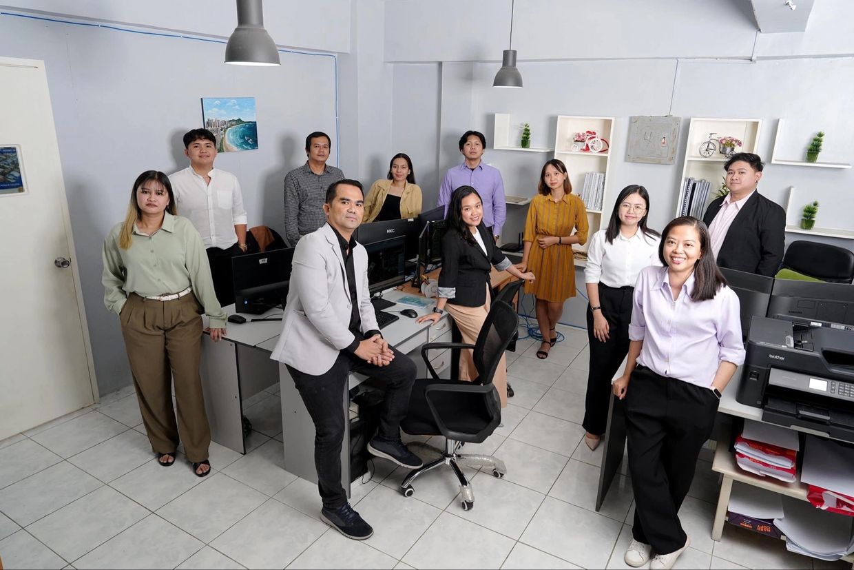 A diverse group of professionals posing in a modern office space.