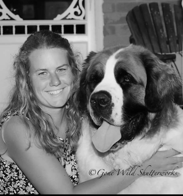 Young woman hugging a large dog, both happy.